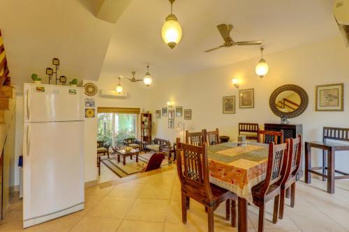 a kitchen and dining room with a table and a refrigerator at Royale Holiday Villa - 4BHK JAQK Holidays in Baga