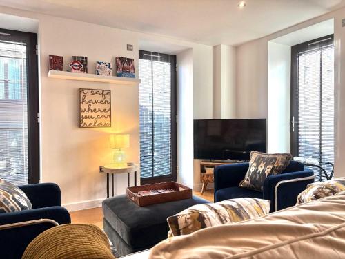 a living room with a couch and a tv at Westminster Luxury Two Bed Two Bath with Air-Con in London