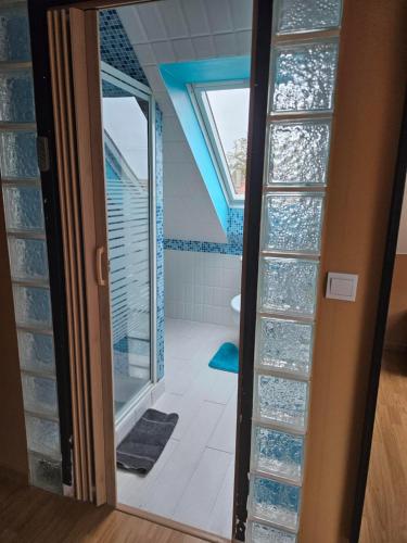a glass door leading to a bathroom with a shower at Chambre d'Hôtes à Magny le Hongre in Magny-le-Hongre