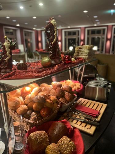 a buffet with many different types of bread and pastries at Hotel Schloss Waldeck in Waldeck