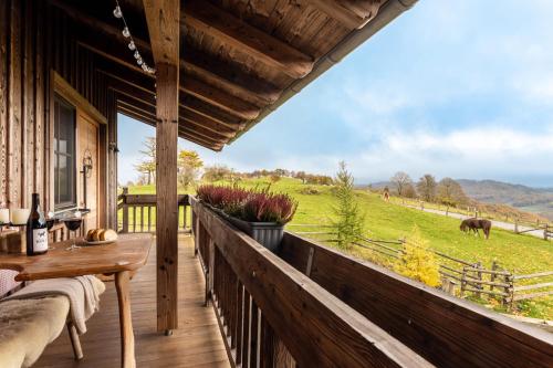 a porch with a table and a view of a field at Chalet Bergliebe in Brilon