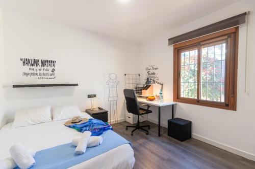a bedroom with a bed and a desk and a window at Villa Elisa in Nerja