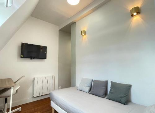 Habitación con cama y TV en la pared. en Trocadéro - Studio 16, en París