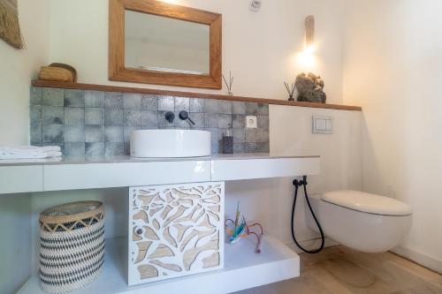 a bathroom with a sink and a toilet at OMAÏA Private villas in Amed