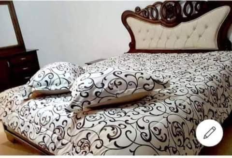 a bed with a black and white comforter and pillows at Bardo centre in Tunis