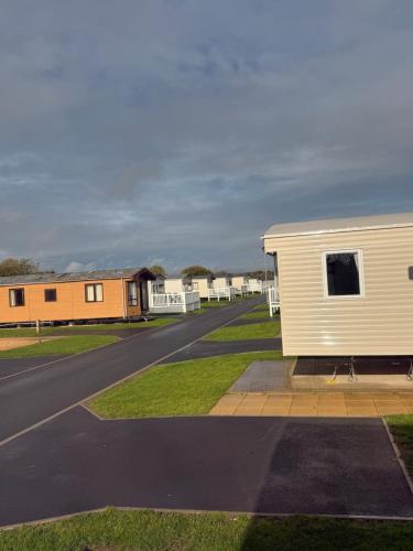タターズホールにあるTattershall Caravan- 28 The Pasturesの道路脇に座る白い小屋