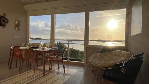 a dining room with a table and chairs and a large window at Tout est neuf dans ce beau Duplex pour 6 à 7p vue lagon in Marigot