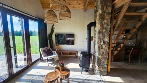 a living room with a fireplace and a stone wall at Drewniane Domki Całoroczne Gryszczeniówka in Wargowo