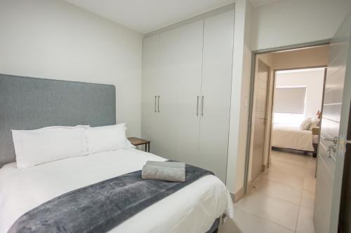 a bedroom with a large white bed and a room at Apartment 35 - 1 On York in George