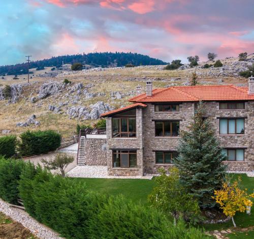 une maison en pierre avec un toit rouge dans l'établissement Chalet Panorama -Three Level Escape in Parnassos, à Arachova