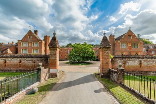an entrance to an old castle with a fence at Wotton House in Dorking