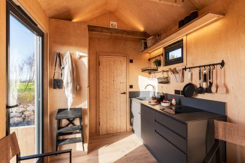 a kitchen in a tiny house with a large window at Cabins at Bogee Farm in Saint Ervan