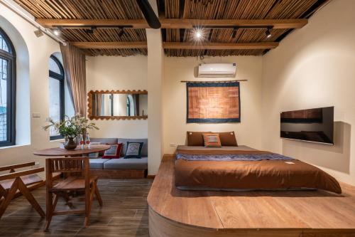 a bedroom with a large bed and a table at The Amber Lotus Hanoi-Elegant Stay with Free Pickup-Near Old Quarter in Hanoi