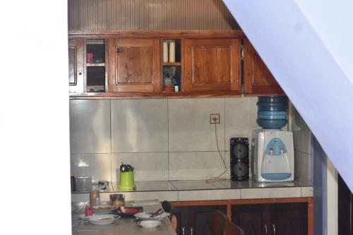 a kitchen with wooden cabinets and a counter top at Mayo Homestay in Ruteng