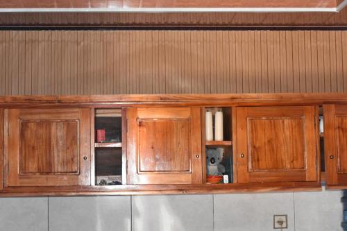 a wooden cabinet on a wall in a kitchen at Mayo Homestay in Ruteng
