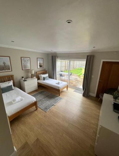 a large room with two beds and a window at The Beach House - Fully refurbed March 2024 in Oystermouth