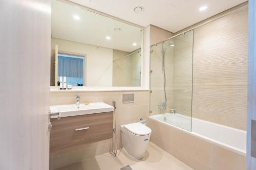 ein Badezimmer mit Toilette, Waschbecken und Dusche in der Unterkunft F1 Lovers Escape Yas Golf Studio Near Yas Marina Circuit in Abu Dhabi