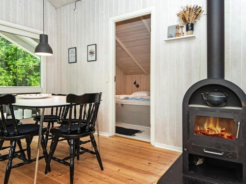 a living room with a fireplace and a table and chairs at Secluded Haven in Hvidbjerg - By Traum Ferienwohnungen in Egeskov