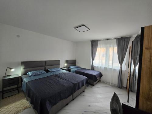 a bedroom with two beds and a window at Apartman Bugi Vukovar in Vukovar