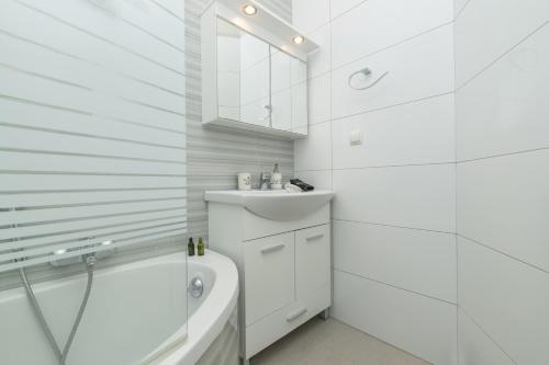 a white bathroom with a sink and a toilet at Demargia Villa A - First Floor Apartment in Áno Yerakaríon