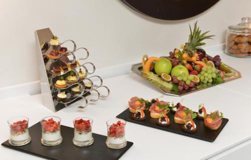a table with three trays of fruit and drinks at Best Western Plus Delta Park Hotel in Mannheim
