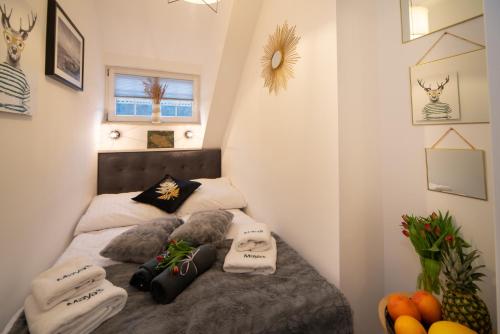 a small bedroom with a bed with two pillows at Maya's Flats - Dluga 66 Attic Gdansk in Gdańsk