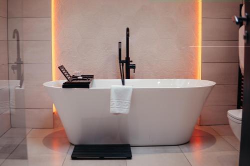 a white bath tub in a bathroom with a toilet at Grey Street Hotel in Newcastle upon Tyne