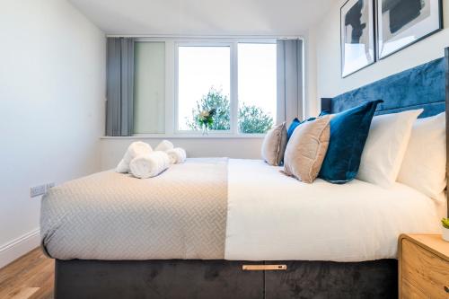 a bedroom with a large bed with blue pillows at Central Gravesend 1BR, Kitchen, Wi-Fi, Sleeps 2, Parking in Gravesend
