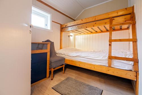 a bedroom with a bunk bed and a desk at Sjøstrand Rorbuer in Ballstad