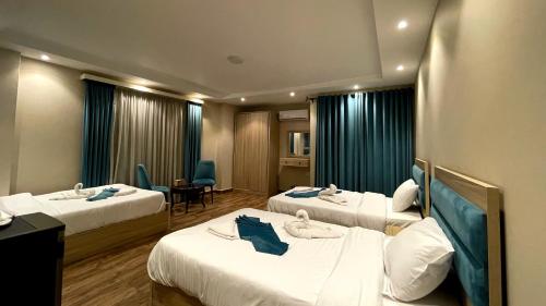 a hotel room with three beds and a table at Gabry Grand Egyptian Museum and Pyramids Hotel in Cairo