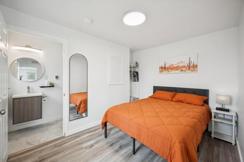 a bedroom with an orange bed and a sink at ModPod 4 