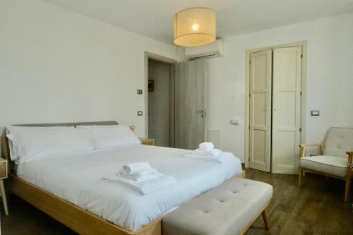 维罗纳Ca' Marì Torricelle Bed&Breakfast的卧室里有一张白色的床和一把椅子