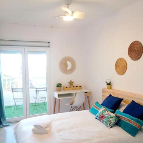 Un dormitorio con una cama y una mesa y un balcón. en Habitación Adra Puerto, en Adra
