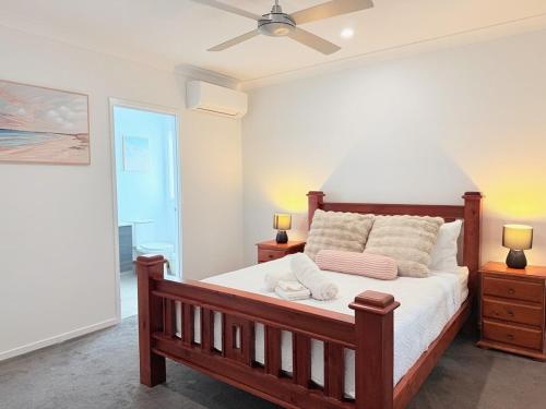 1 Schlafzimmer mit einem Bett, 2 Lampen und einem Deckenventilator in der Unterkunft Spacious Family Home 4B2B in Browns Plains in Browns Plains