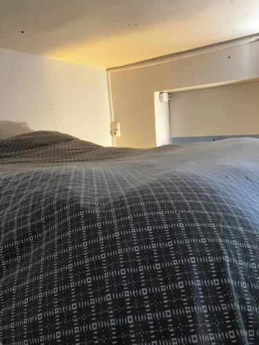 een slaapkamer met een bed met een deken erop bij Nice place Paris center in Parijs