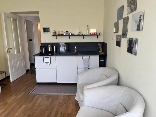 a kitchen with a counter and two chairs in a room at appartamentoviaguedoz in Aosta