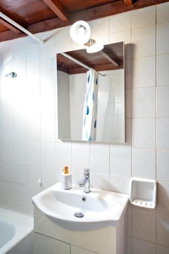 a white bathroom with a sink and a mirror at Villas Mina and Studios in Gennadi