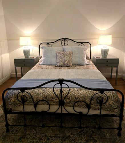 a bedroom with a bed with two lamps on two tables at CERULEAN HOUSE - Iconic Renovated Period Home - Close to Everything in Bendigo