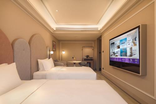 a hotel room with two beds and a flat screen tv at Mercure Xi'an History Museum in Xi'an
