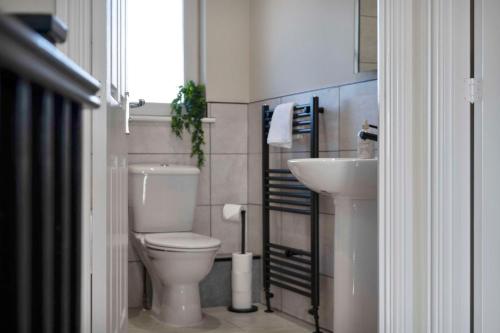 a small bathroom with a toilet and a sink at Dunfermline Retreat 3br Wi-fi Private Parking in Townhill