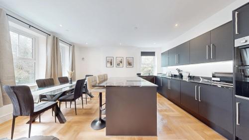 eine Küche mit einem langen Tisch und Stühlen in einem Zimmer in der Unterkunft Luxury Penthouse Duplex in Newport