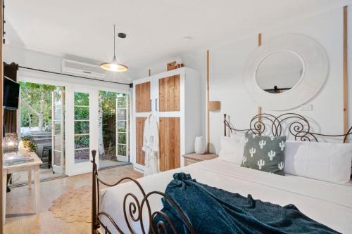 a bedroom with a white bed and a mirror at Studio Spring Hill Holiday Units Pet friendly in Point Lonsdale