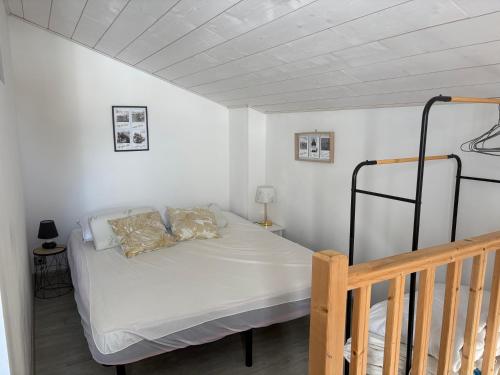 a small bedroom with a bed and a staircase at Maisonnette à 30 mètres de la plage in Saint-Denis-dʼOléron