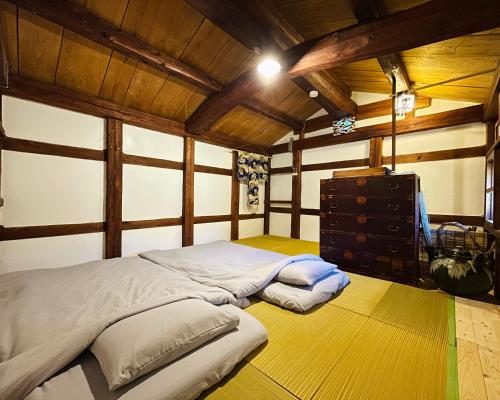 a large bed in a room with wooden ceilings at 蔵の宿 隠れ蔵 Kakurekura Traditional Private Stay in Nagahama