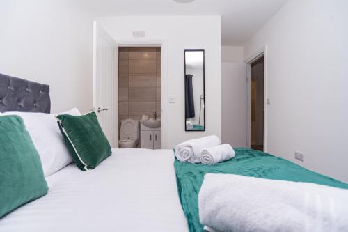 a bedroom with two beds with green and white pillows at Maple - Telford House - With Parking in Telford