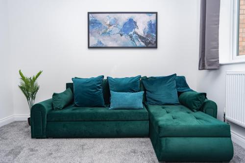 a green couch in a living room with a painting at Maple - Telford House - With Parking in Telford