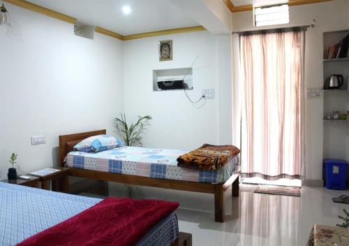 a bedroom with two beds and a window at Pink City Heritage Homestay in Jaipur