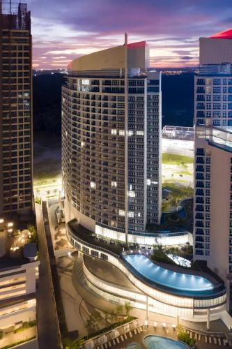 a night view of a city with tall buildings at UHF HOTELS and RESORTS PINETREE in Iskandar Puteri