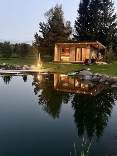 a house reflecting in the water at night at IKnamai in Sakiniai
