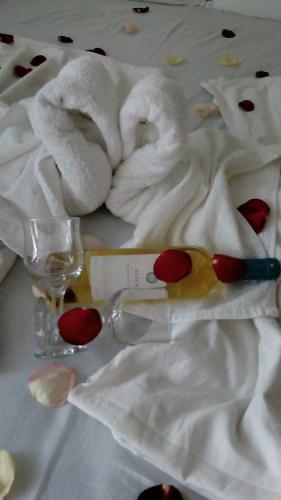 a pair of towels and a glass on a bed at Rali Apartments in Kiten